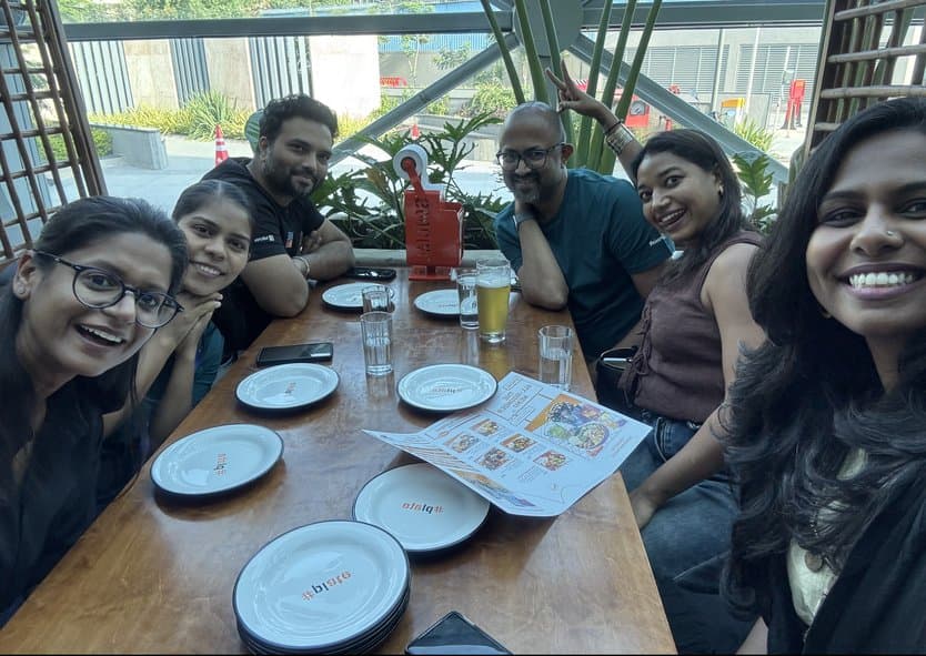 Teammates taking a selfie around a table with plates and drinks