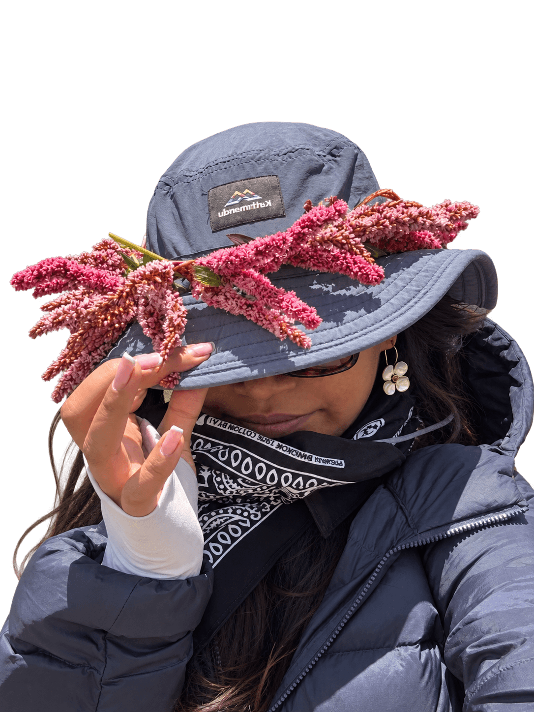 Supriya in a bucket hat decorated with pink flowers, tipping the brim